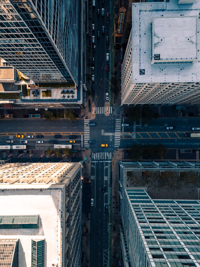 High angle photo of busy urban intersection with skyscrapers and traffic.